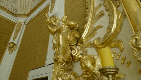 golden sculptures that are part of the altar in the chapel, located on a richly decorated wall
