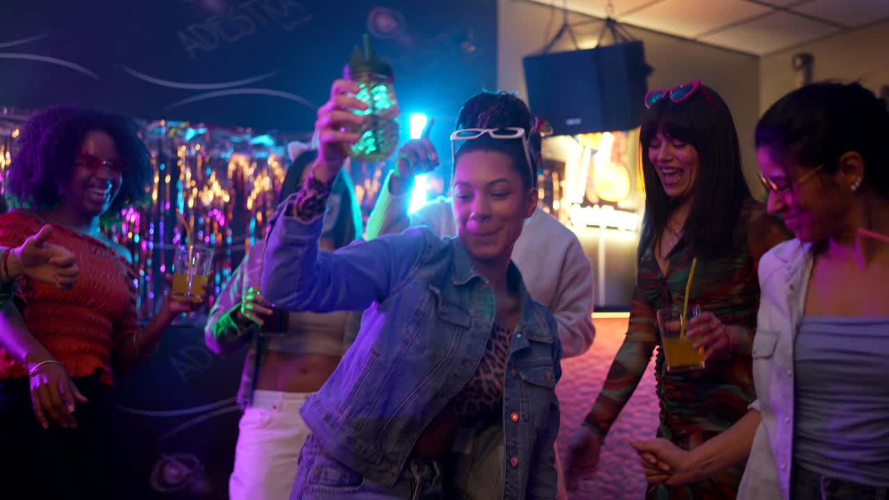 Gruppo di giovani amici che ballano e festeggiano in una discoteca vivace