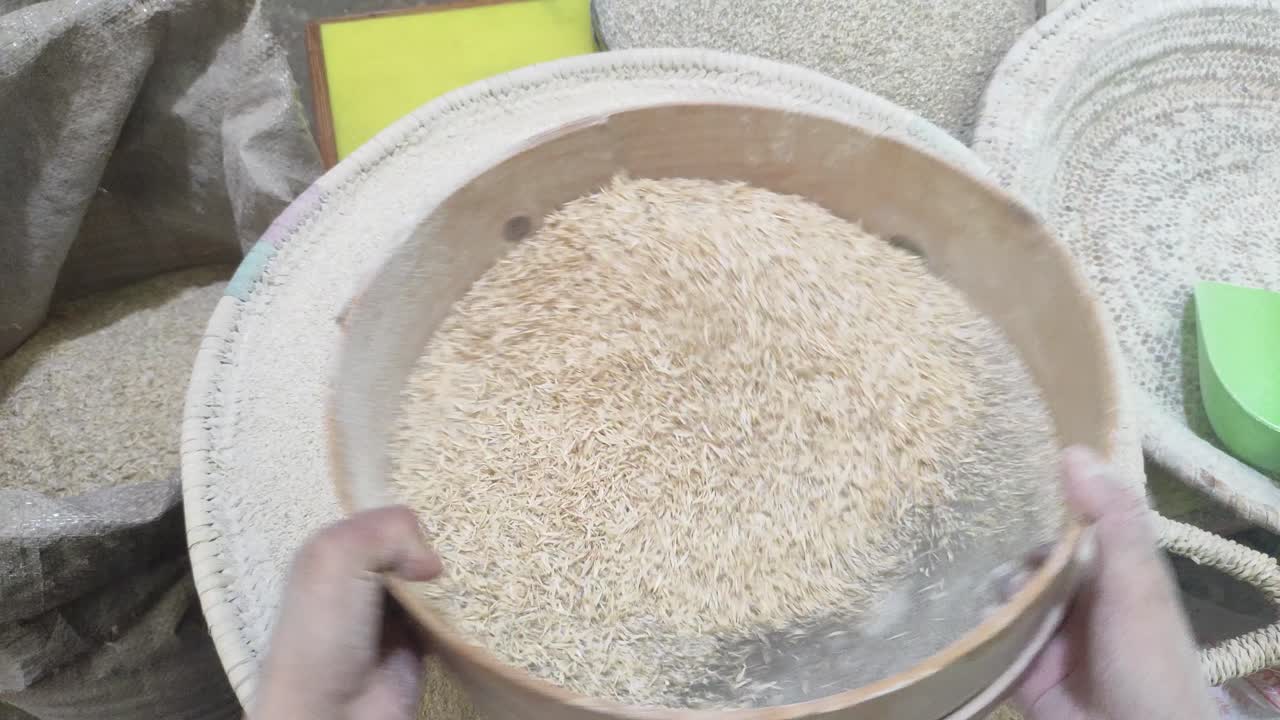 Kotitekoisen leivän leivonnan taito, kun nainen siivilöi taitavasti jauhoja, mikä on ratkaiseva vaihe herkullisten leipien luomisessa, omassa kotikeittiössään. Marokko.