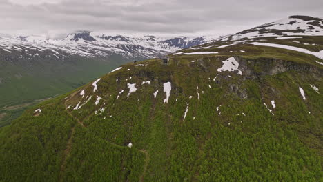 tromsø noruega drone aéreo v16 vuela alrededor del monte storsteinen hacia la estación superior de fjellstua con parches de nieve derretida en la montaña durante el comienzo de la temporada de verano - filmado con cine mavic 3 - junio de 2022