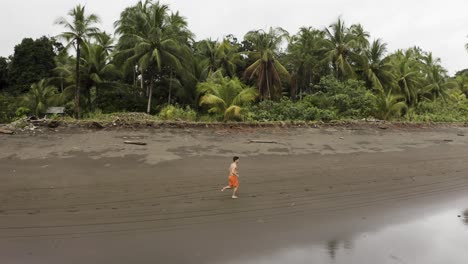 Antena-Sigue-A-Un-Joven-Trotando-En-Una-Playa-Vacía-En-Choco,-Colombia