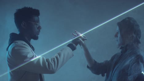 multiethnic couple holding hands in dark room with laser light sheet