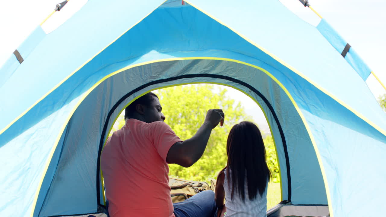 African American, Father and daughter enjoying quality time together in cozy camping tent