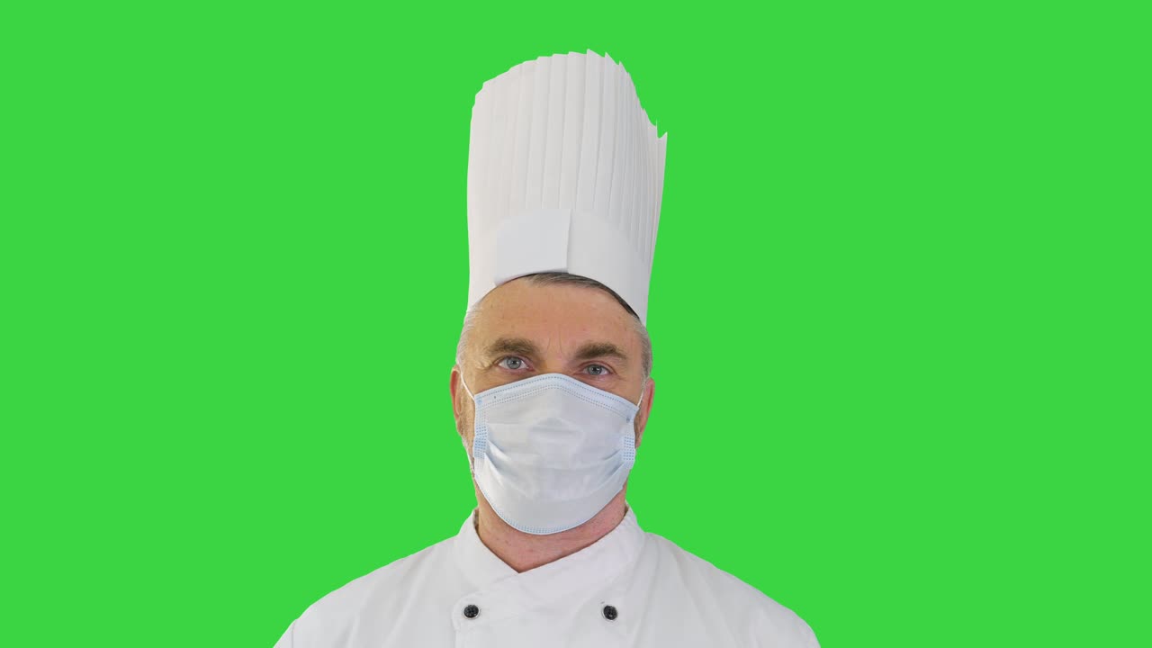 Cuoco uomo che indossa una mascherina protettiva medica per la protezione dalle malattie virali su uno schermo verde, Chroma Key