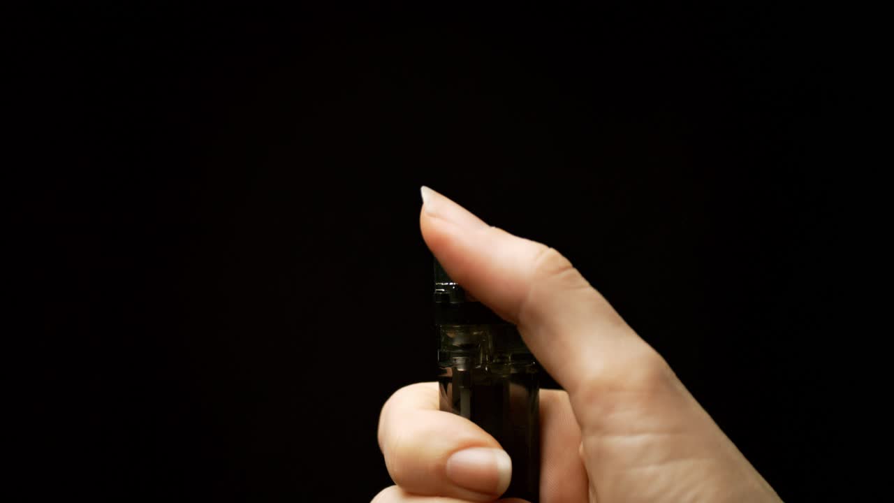 llamas parpadeantes: sea testigo de la cautivadora transformación de chispas a llamas a medida que una mano activa un encendedor en una hipnotizante escena en cámara lenta