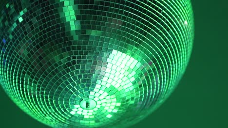 Shiny-disco-ball-rotating-under-ceiling-during-party