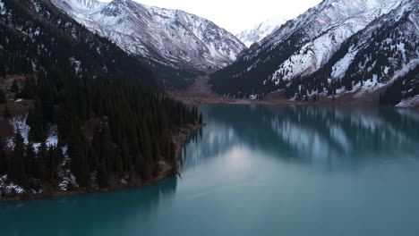 Großer-Almaty-See-Und-Schneebedeckte-Berge-Kasachstans---Schwenken,-Neigen,-Drohnenaufnahme