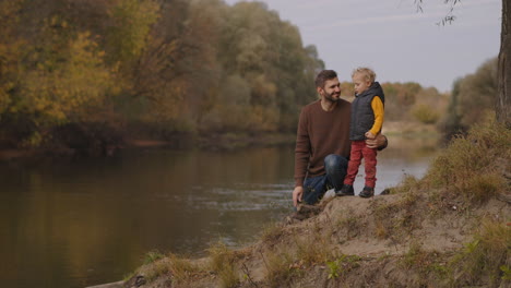 happy childhood of little boy spending time with father at forest park at autumn day weekend at nature little trip in woodland