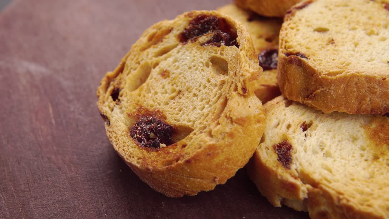 Crostini secchi al forno con uvetta. Cracker di pane croccanti su un tagliere di legno rustico