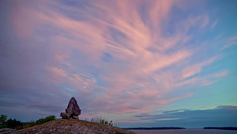 Stacked-Stones-On-A-Hill-Against-Blue-Summer-Sky-With-Feathery-Clouds