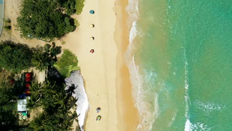 4k cinematic nature aerial footage of a drone flying over the beautiful beach of surin in phuket, thailand on a sunny day