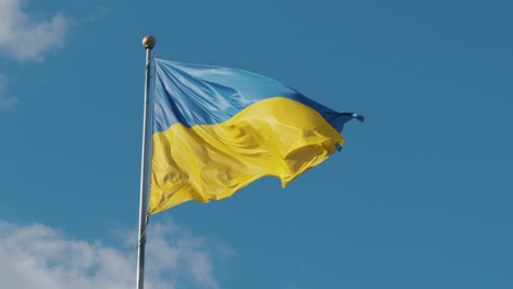 ukraine flag in slow motion with blue sky background