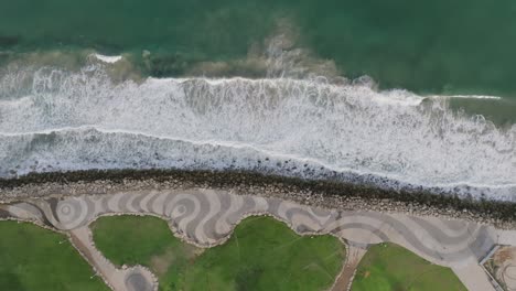 Von-Oben-Nach-Unten-Aufgenommene-Luftaufnahmen-Der-Wellen,-Die-An-Den-Strand-Vor-Der-Küste-Von-Tel-Aviv,-Israel,-Rollen