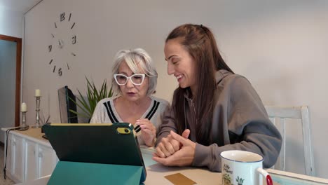 grandmother and granddaughter using tablet at home