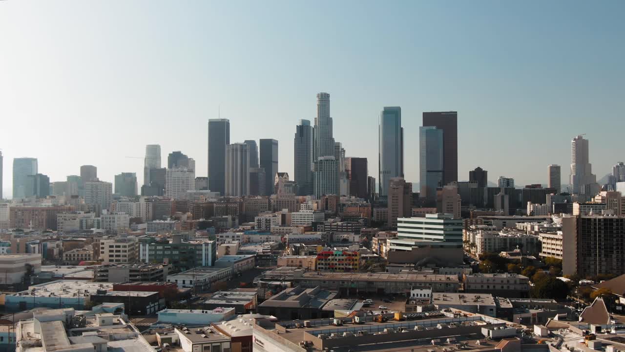 Inquadratura d'apertura dello skyline di Los Angeles sotto il sole splendente, ripresa aerea in allontanamento.