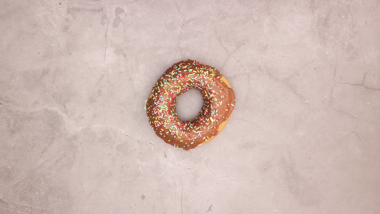 las deliciosas rosquillas de chocolate giran en círculo sobre la mesa - detenga el movimiento