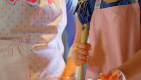 vista frontal de la madre y la hija horneando galletas en la cocina de una casa cómoda 4k