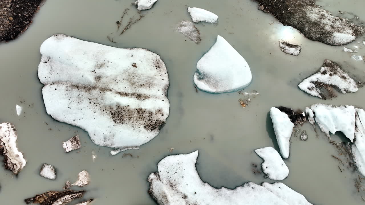 Huge boulders of ice in grey water. Ice melting in Alaska, USA. Aerial view
