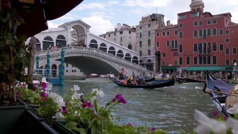 a gondola boat in the canals of venice italy on a summer day at ponte del rialto