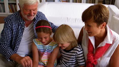 grandchildren using laptop with their grandparents