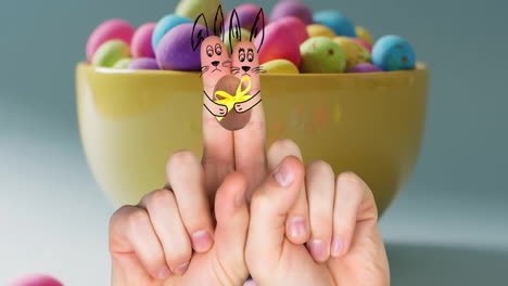 animación de dedos con conejitos de pascua y huevo de pascua sobre un cuenco de huevos de pascua en fondo azul