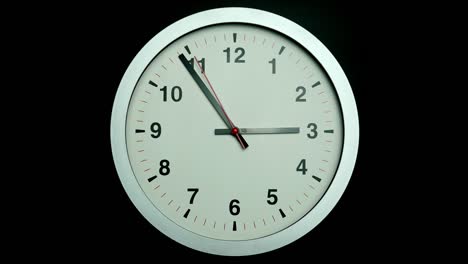 white wall clock tells the time.