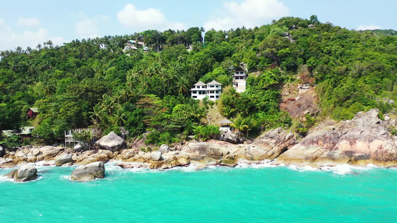 야자수 숲이 있는 태국 섬의 바위 해안에 있는 고급 호텔과 리조트