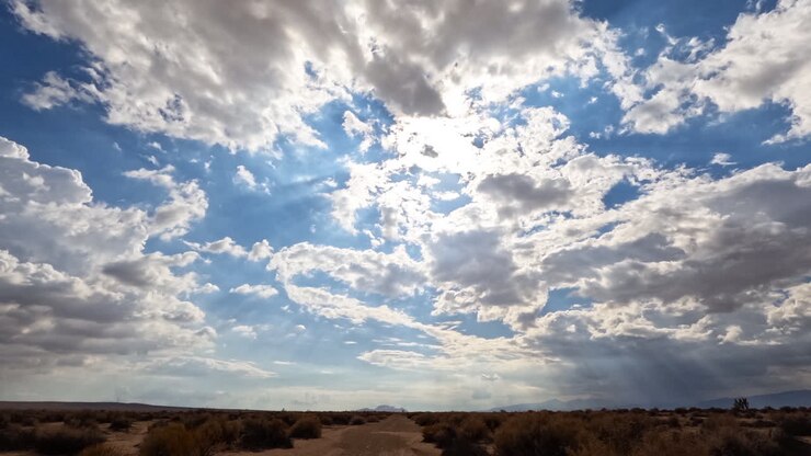 Nubes formándose y disipándose sobre el árido y arenoso paisaje del desierto de Mojave - time lapse