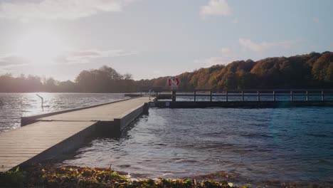 bridge by gyllebo lake with life saving bouy by the autumn sunset - static wide shot