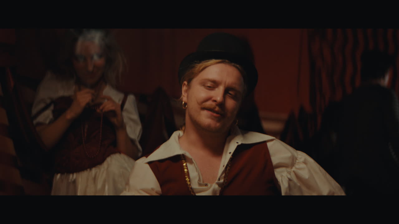 A man in hat smokes a cigar in the circus camp