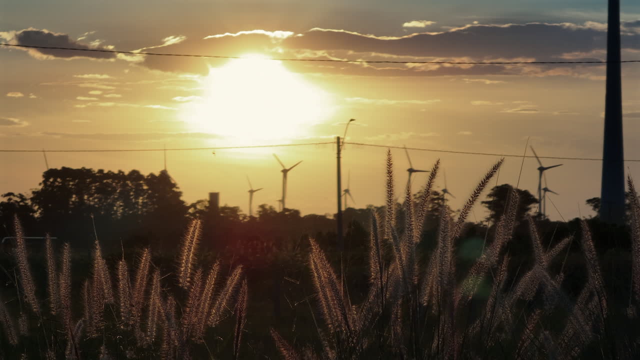 Parallax-luftoptagelse i biografstil med 7x teleobjektivkomprimering, der viser Texas-græs og slørede vindmøller ved solnedgang i 4K