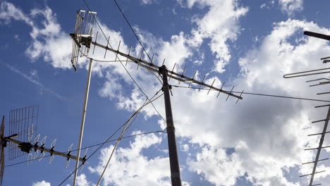 A timelapse of the sky and clouds with television aerials in the foreground