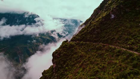 Vuelo-Lateral-De-Drones-A-Lo-Largo-De-Un-Sendero-De-Trekking-Con-Nubes-Post-lluvia,-Un-Paisaje-Verde-Exuberante-Y-Una-Zona-De-Descanso-Pintoresca