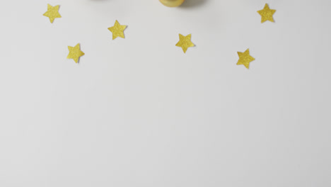 video of christmas decorations with gold baubles and stars with copy space on white background