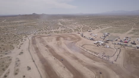 Aerial-pan-of-cars-racing-on-a-dirt-racetrack-in-the-Mojave-Desert,-California