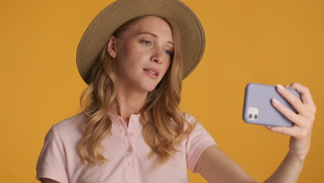 caucasian woman in a hat having video call on smartphone.