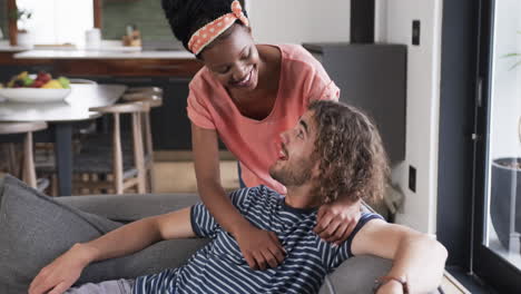 diverse couple, a young african american woman and caucasian man, share a moment at home