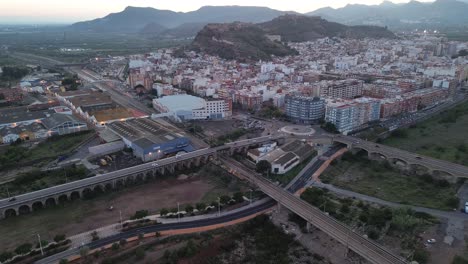 aerial view of a city with a castle and bridges at sunset