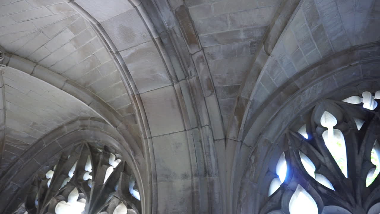 Pan across rib vaulted ceiling and gothic window tracery