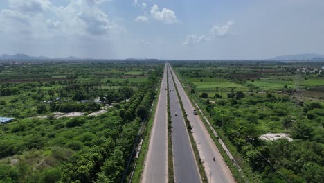 aerial view of a long highway cutting through lush green countryside