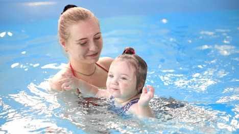 cute baby boy enjoying with his mother in the pool.