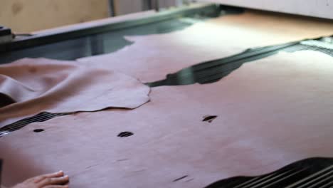 leather being processed over an industrial machine in a factory in ethiopia, africa. close-up shot