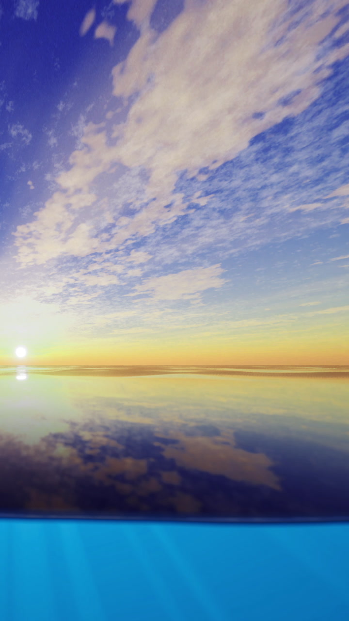 Sunrise over calm sea with blue water and clouds in the sky