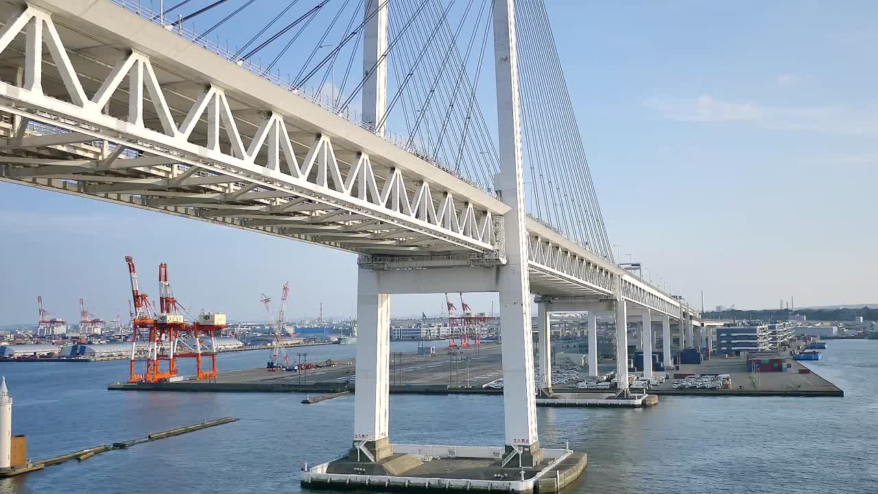 A wide shot of the Yokohama Bay Bridge taken from the cruise ship top deck, capturing ocean views and towering bridge spans