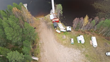 Campers-Parked-By-The-Lakeshore-With-Autumn-Forest-In-Sweden,-Europe