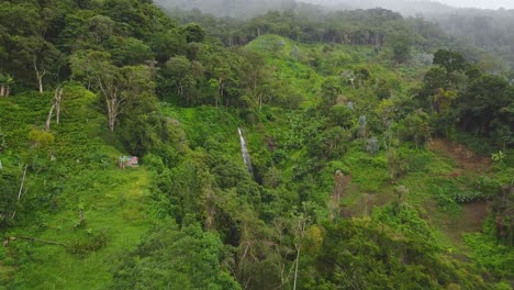 El-Dron-Vuela-A-Una-Pequeña-Cascada-En-Medio-De-Una-Ladera-Boscosa-Y-Nublada-En-Un-Día-Nublado