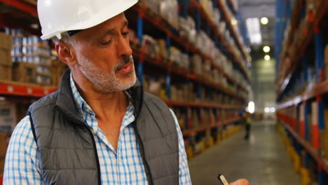 warehouse worker writing on clipboard