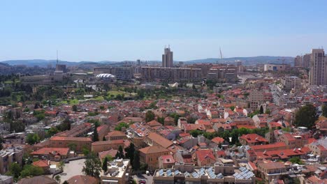 aerial view of a sprawling cityscape with red-roofed buildings and modern structures