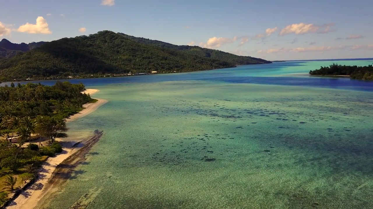 Luftfoto fra drone af Fransk Polynesien, der viser turkise lagunevande, hvide sandstrande og frodige palmeskove mod grønne vulkanske bjerge. Øerne Bora Bora, Huahine, Tahiti, Rangiroa.