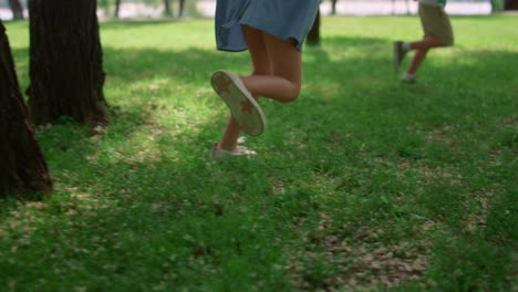 Unrecognized-kid-legs-run-on-green-lawn.-Happy-children-play-on-fresh-grass.